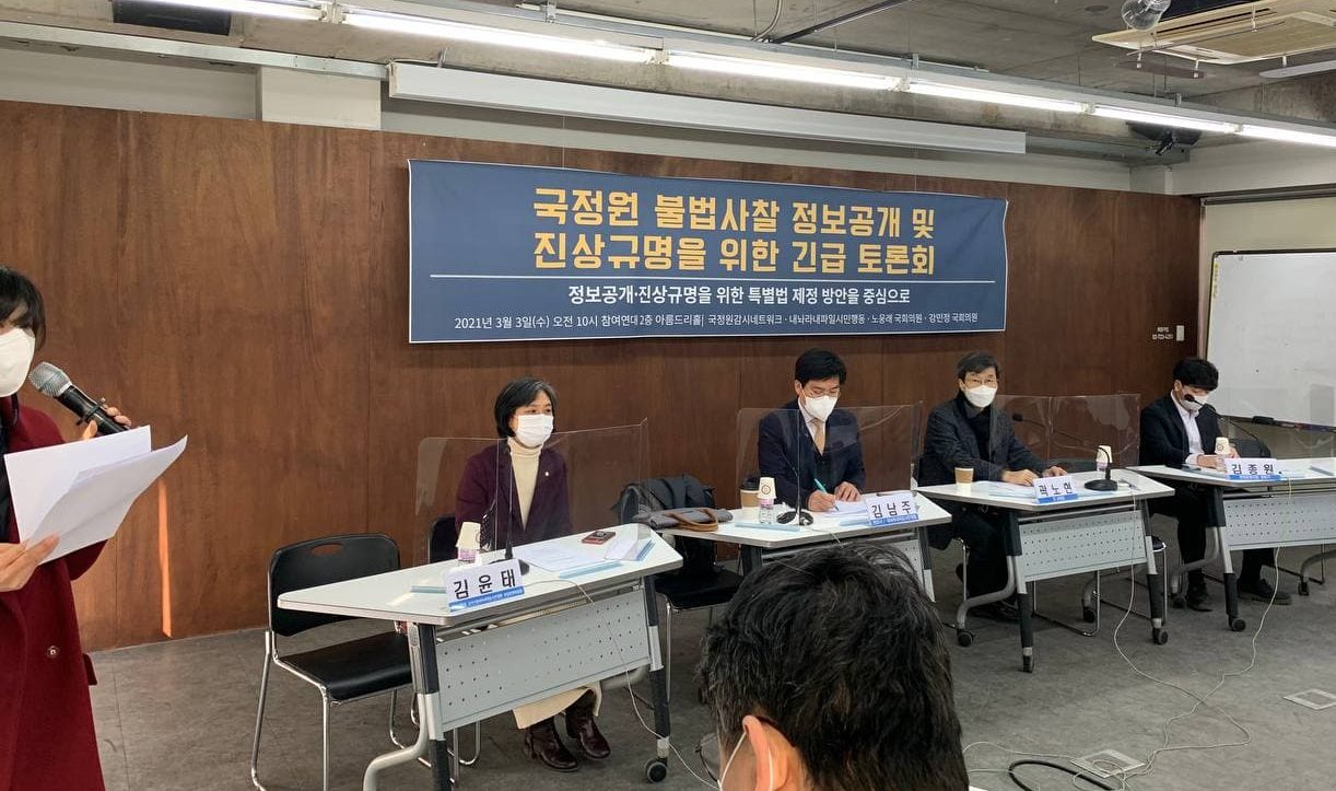 국정원 불법사찰 정보공개 및 진상규명을 위한 긴급토론회 사진. 같은 내용의 현수막 앞 테이블에 앉아 있는 토론회 참가자들이 마스크를 착용한 채 발언하고 있다.
